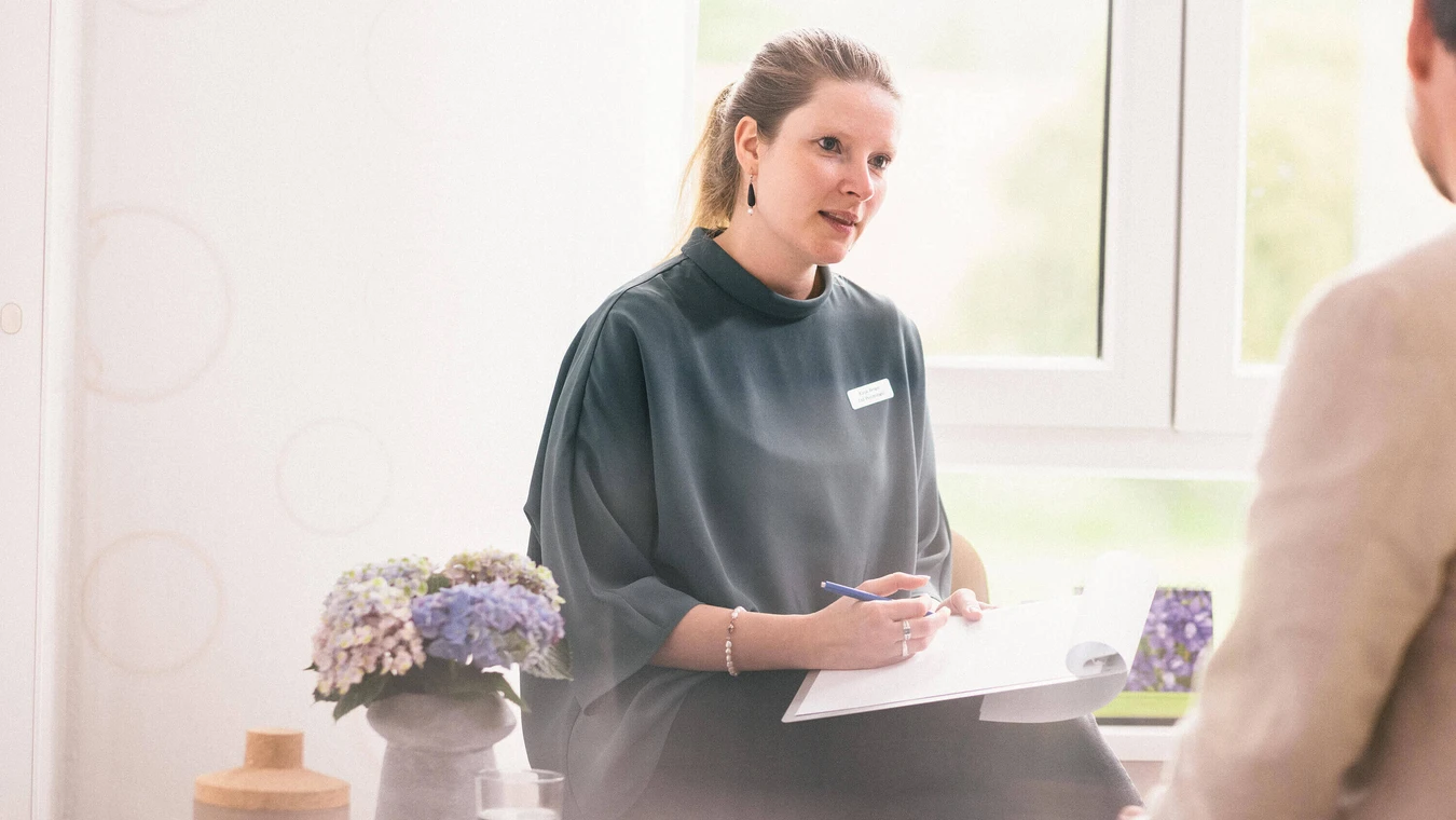 Therapeutin mit notiert im Gespr&auml;ch auf Klemmbrett